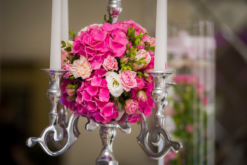 A vibrant floral arrangement featuring a bouquet of pink hydrangeas, light pink roses, white lisianthus, and delicate peach carnations, all arranged in a compact, rounded style. The flowers are fresh 